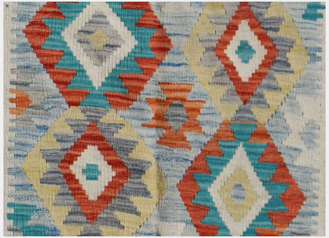 Handwoven Afghan Maimana kilim featuring a geometric diamond pattern in vibrant multicolored wool.