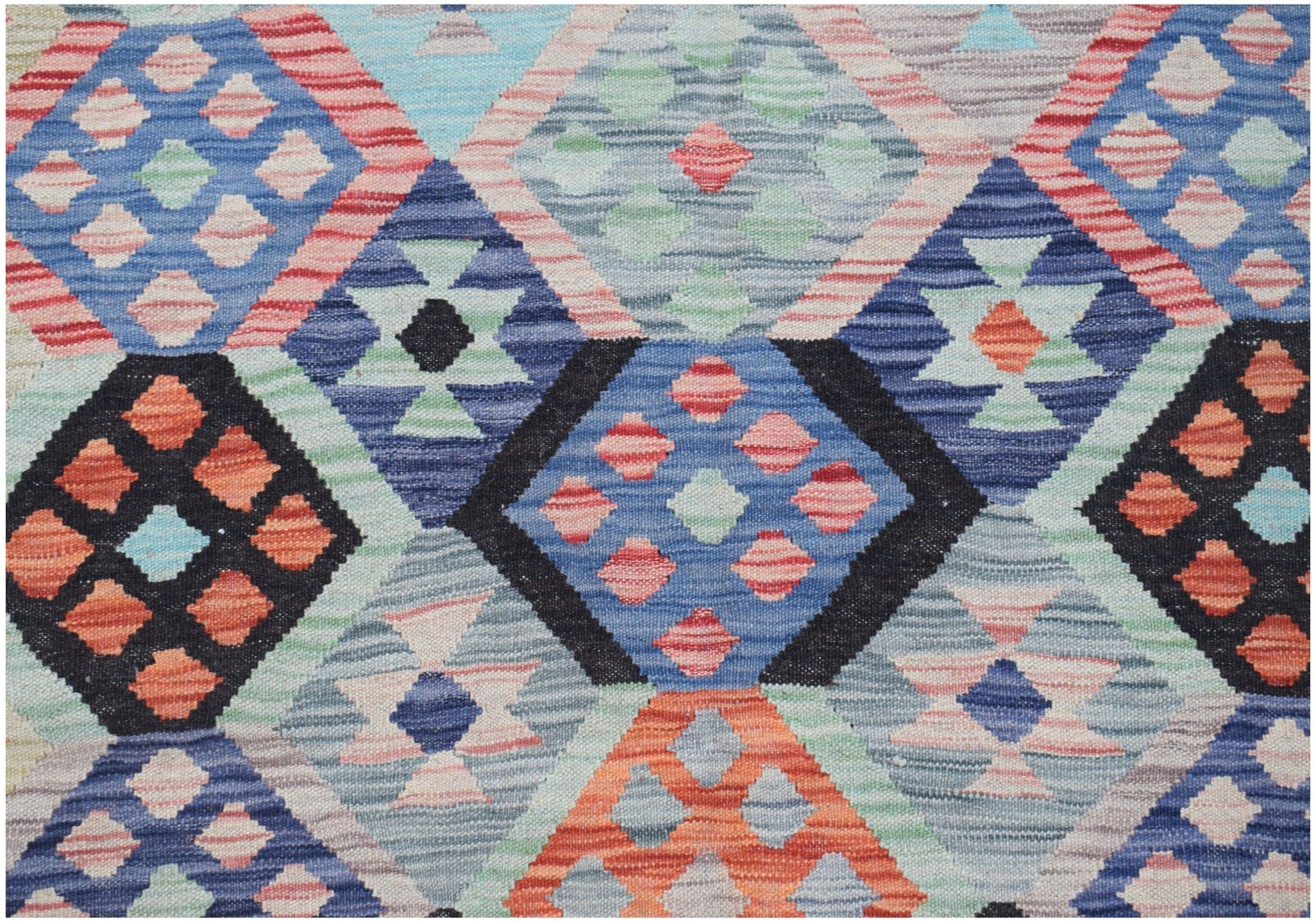 Handwoven Afghan Maimana kilim featuring a geometric diamond pattern in vibrant multicolored wool.
