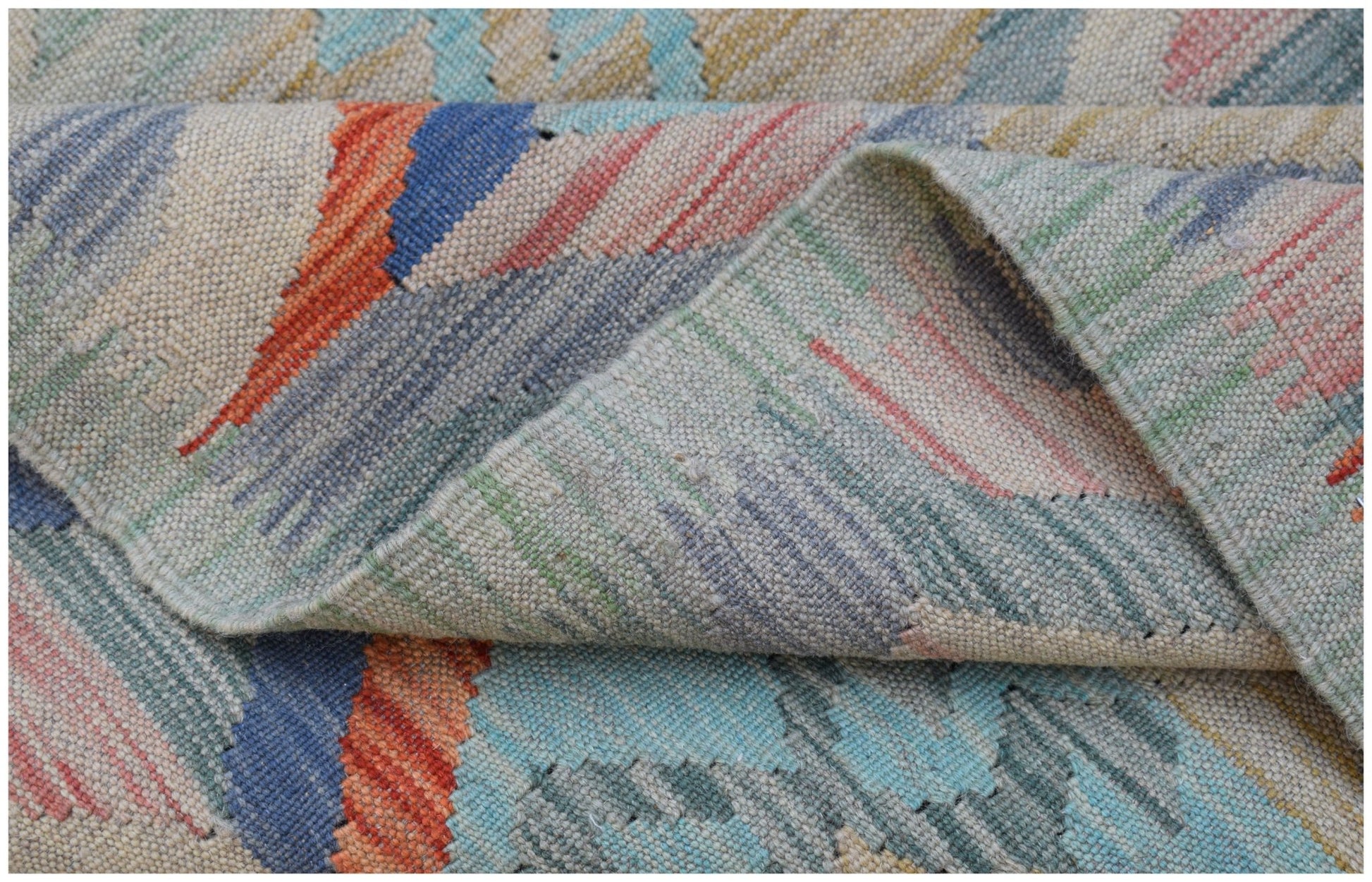 A handwoven Afghan Maimana kilim rug featuring a colorful geometric pattern and flatweave texture.
