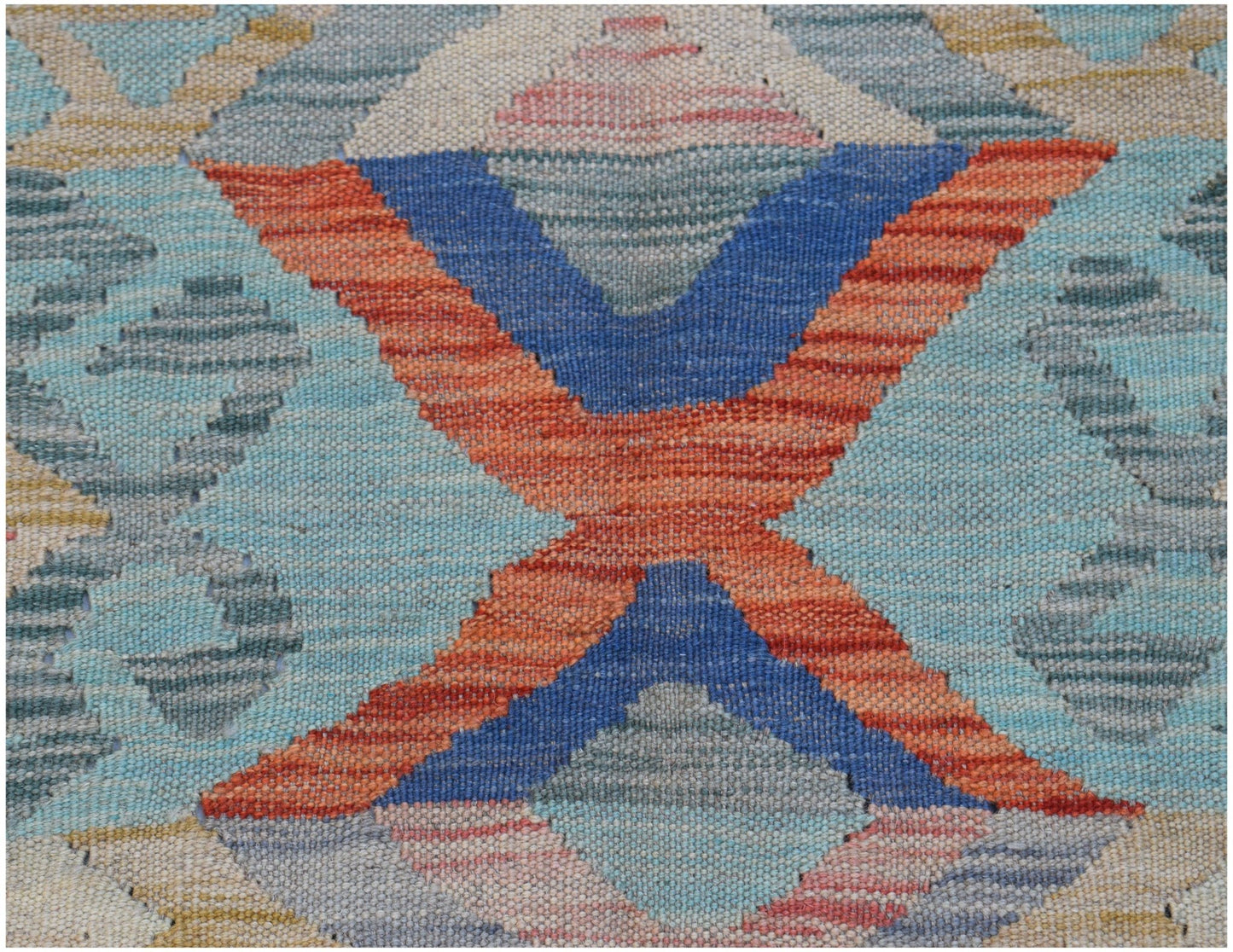 A handwoven Afghan Maimana kilim featuring a geometric pattern in blue, orange, and soft tones.