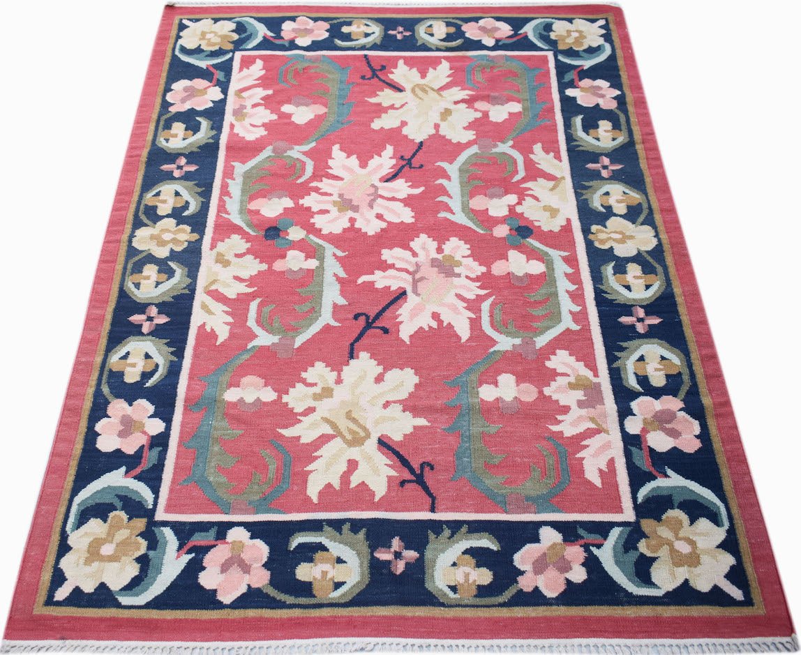 Handwoven Afghan Maimana kilim rug featuring a floral pattern in pink, blue, and cream wool.