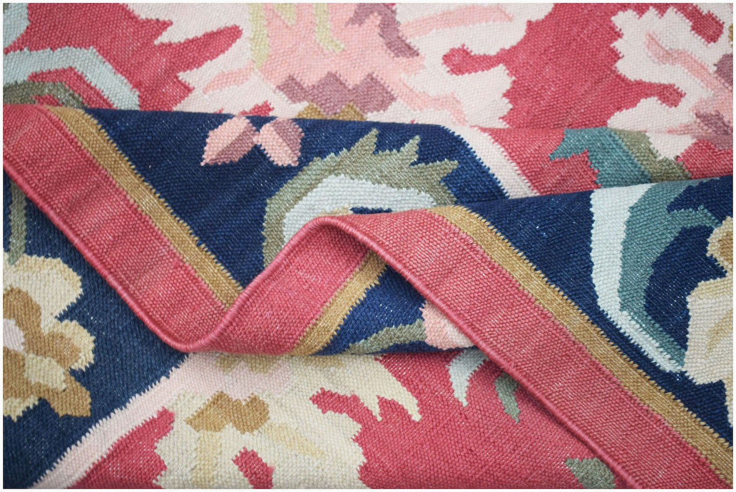 A handmade Afghan Maimana kilim rug featuring a flatweave texture and geometric floral patterns.