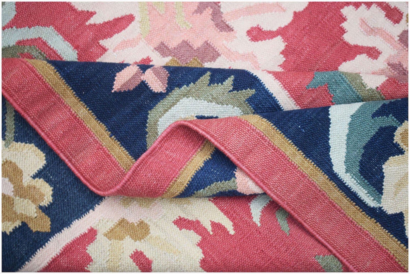 A handmade Afghan Maimana kilim rug featuring a flatweave texture and geometric floral patterns.