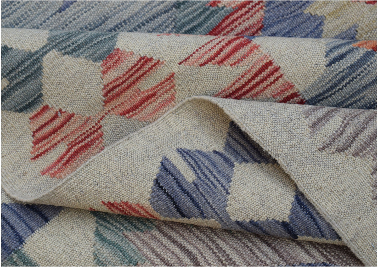 A handwoven Afghan Maimana kilim featuring a geometric pattern in blue, red, and cream wool.