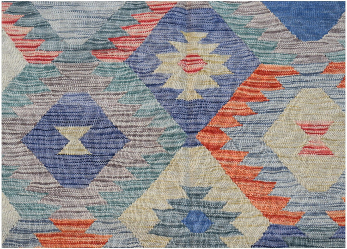 Handwoven Afghan Maimana kilim featuring a geometric diamond pattern in vibrant multicolored wool.