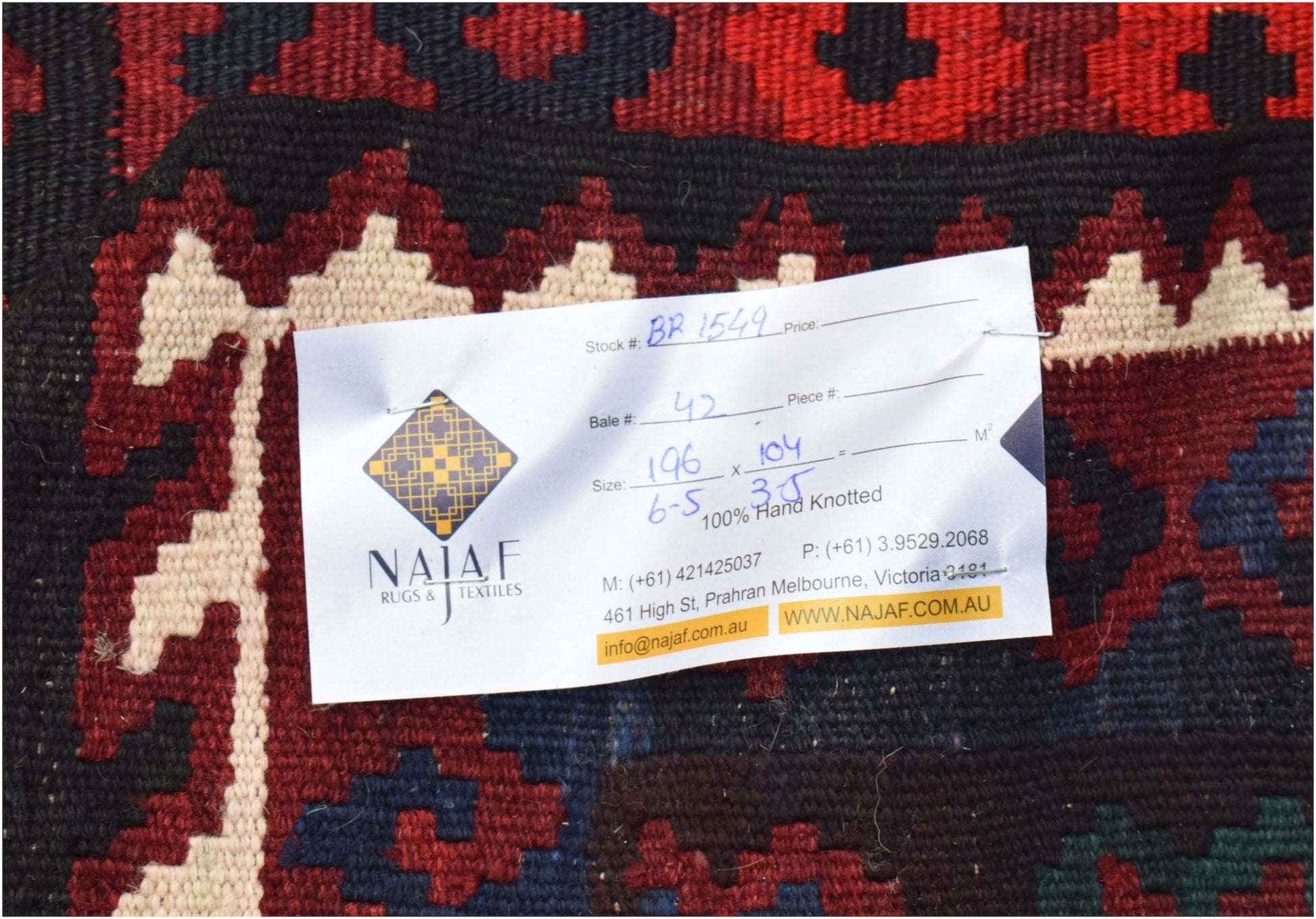 A close-up view of a handwoven Afghan Maimana Kilim featuring geometric patterns in red and blue.