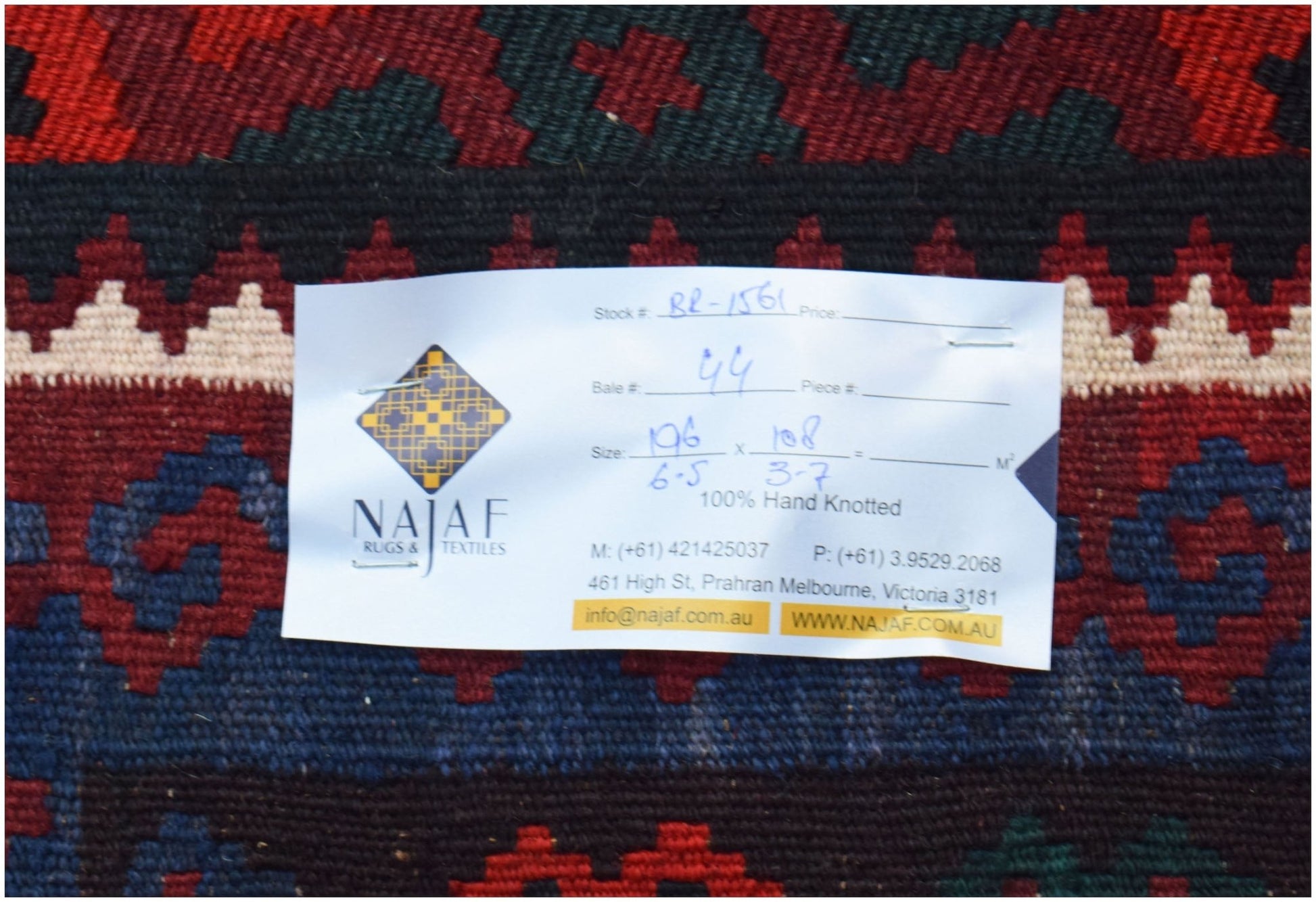 A handwoven Afghan Maimana kilim featuring a geometric pattern in red, blue, and cream tones.