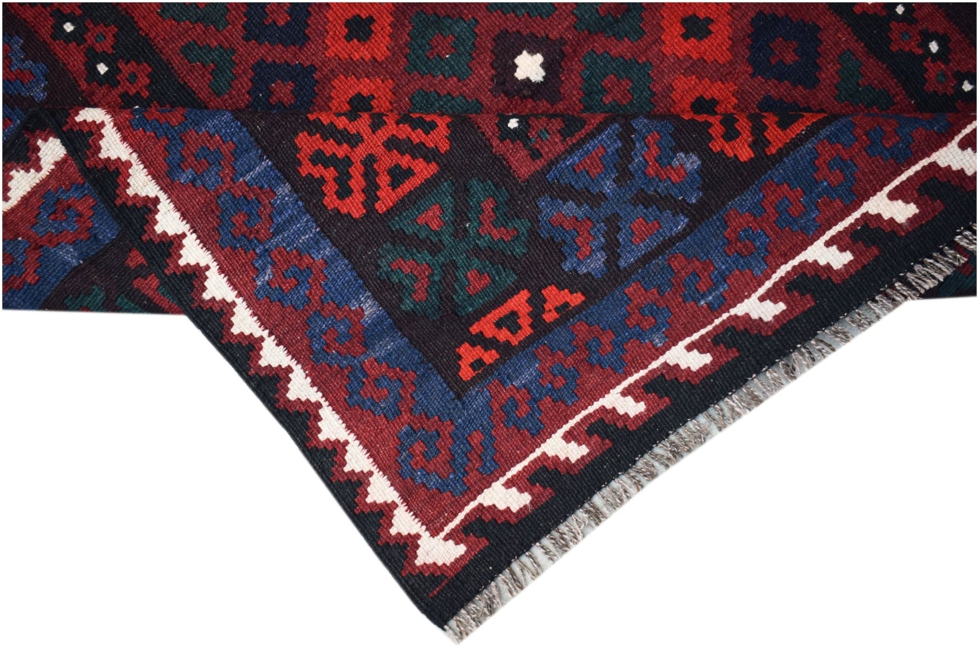 A handmade Afghan Maimana kilim featuring a geometric pattern in red, blue, and dark tones.