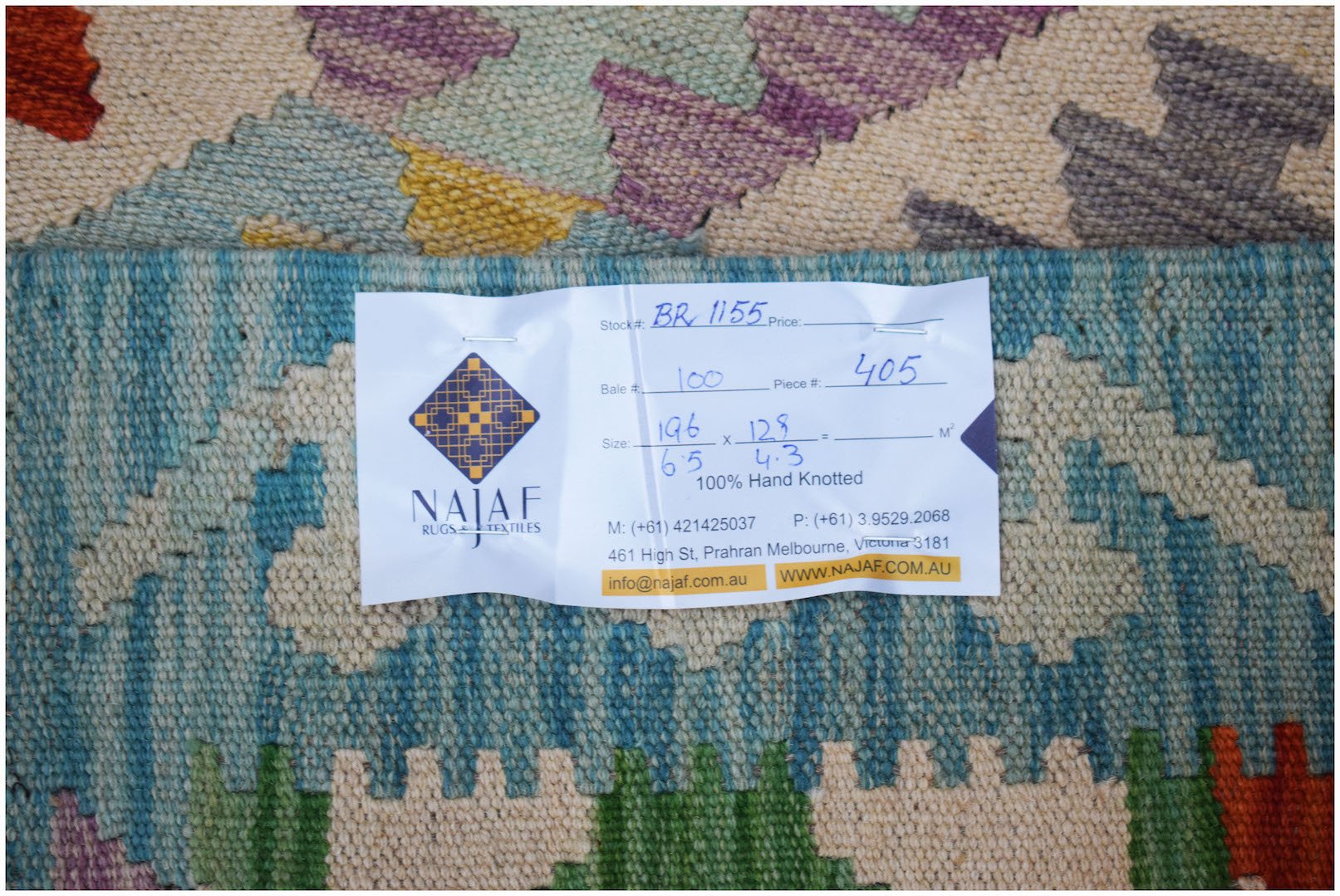 A handwoven Afghan Maimana Kilim rug featuring a colorful geometric pattern.