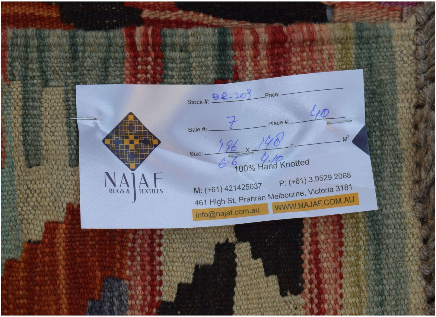 A handmade Afghan Maimana kilim featuring a geometric pattern in rich, warm colors.