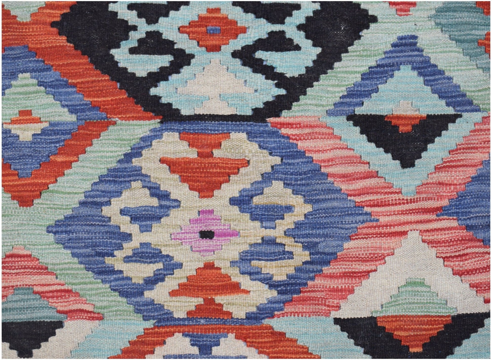Handwoven Afghan Maimana kilim featuring a vibrant geometric pattern in wool.