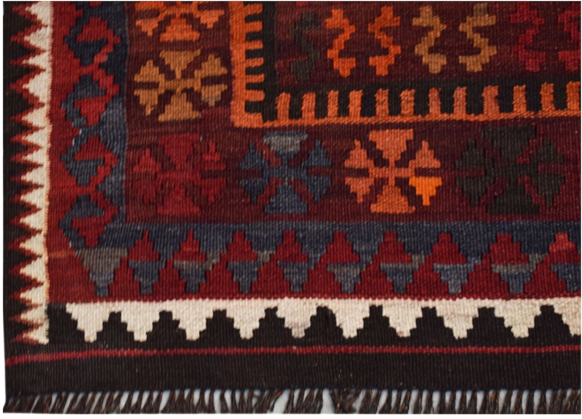 A handmade Afghan Maimana kilim featuring geometric patterns in rich red, orange, and blue tones.