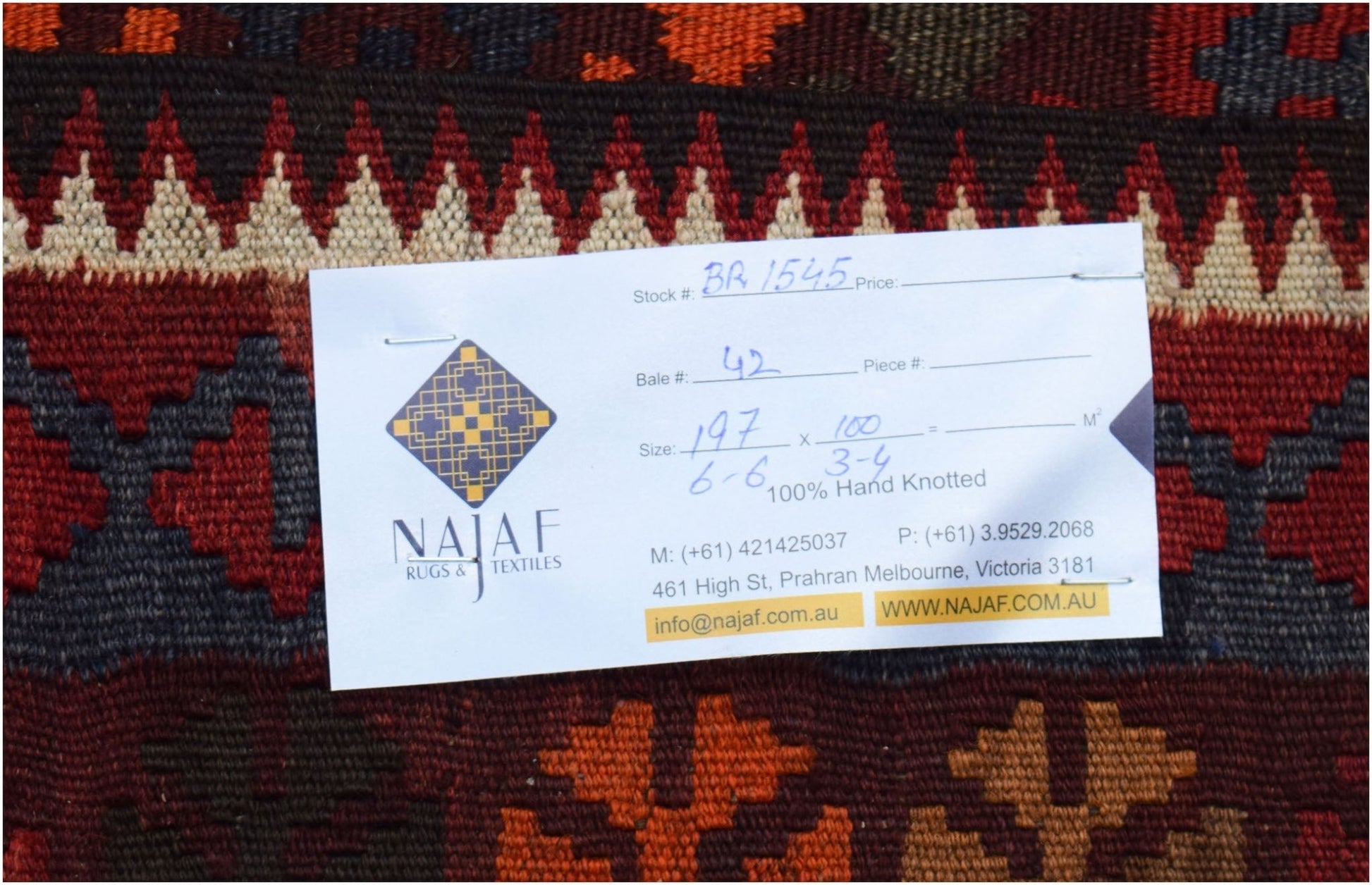 A flatwoven Afghan Maimana Kilim featuring geometric patterns in rich red, orange, and dark tones.