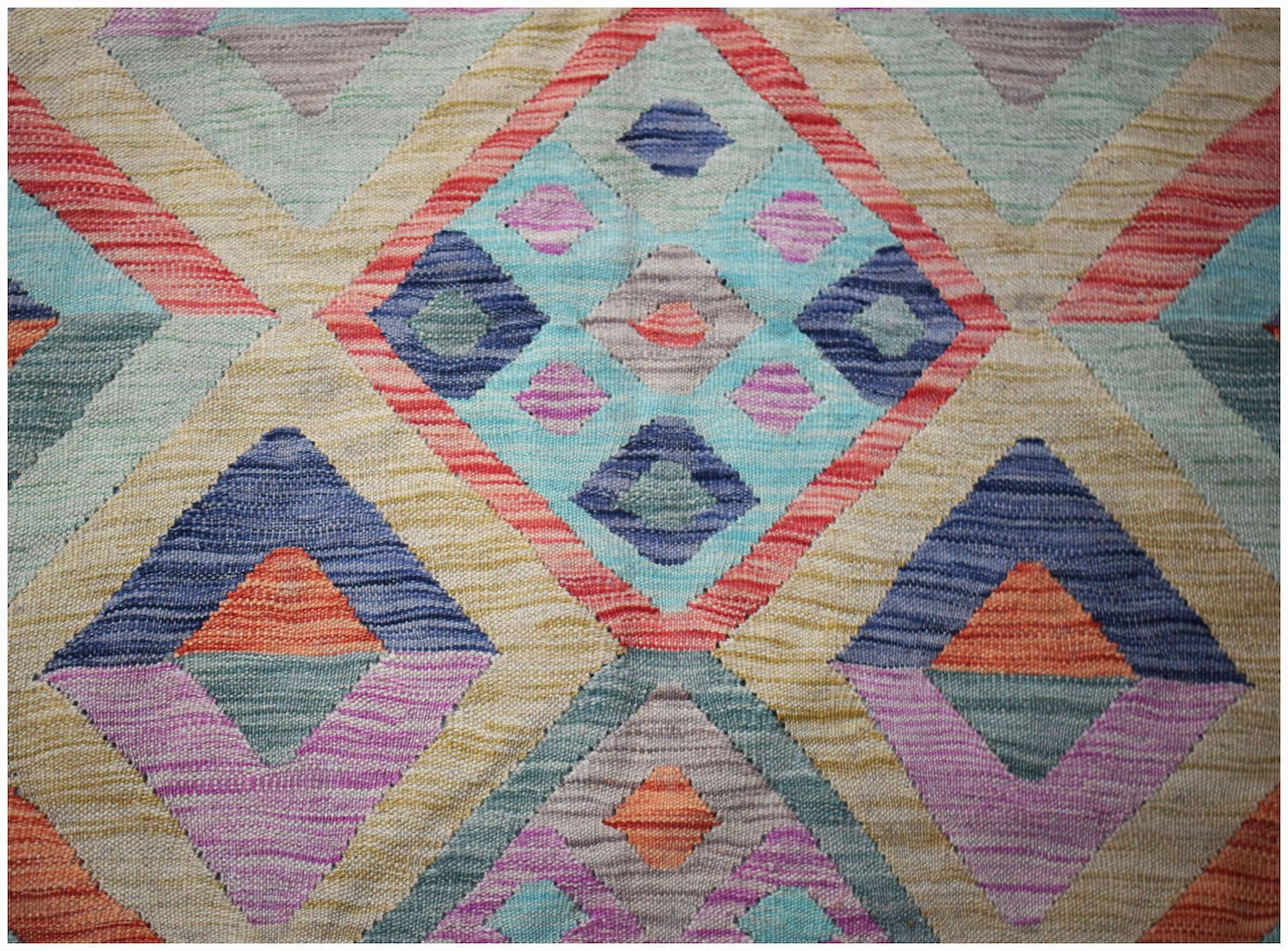 Handwoven Afghan Maimana kilim rug featuring a colorful geometric diamond pattern in wool.
