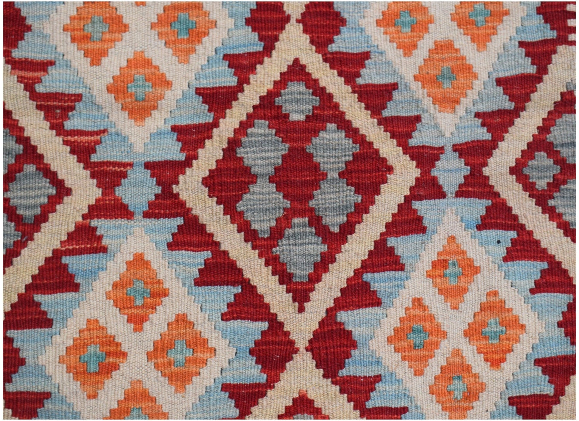 Handwoven Afghan Maimana kilim featuring a geometric diamond pattern in red, orange, and blue.