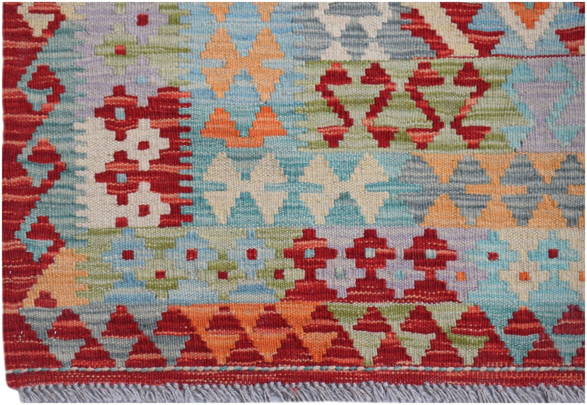 Handwoven Afghan Maimana kilim rug featuring a colorful geometric pattern in wool.