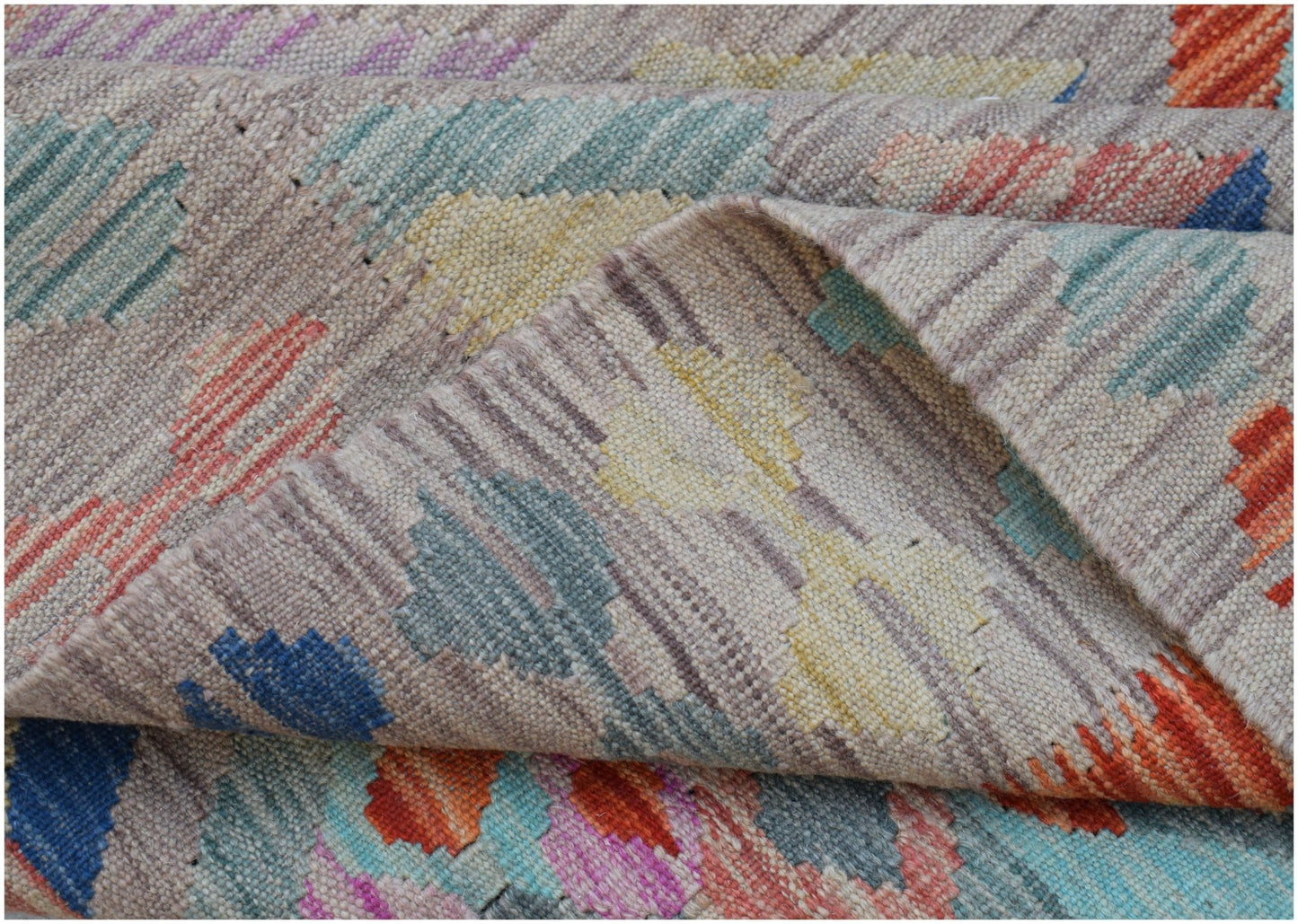 A handwoven Afghan Maimana kilim rug featuring a geometric pattern in vibrant multicolored wool.