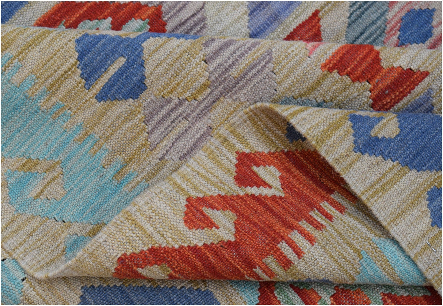A handwoven Afghan Maimana kilim rug featuring a geometric pattern in vibrant wool colors.