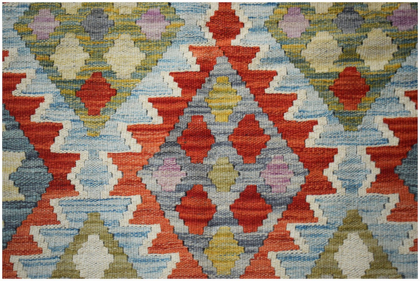 Handwoven Afghan Maimana kilim featuring a geometric diamond pattern in vibrant multicolored wool.