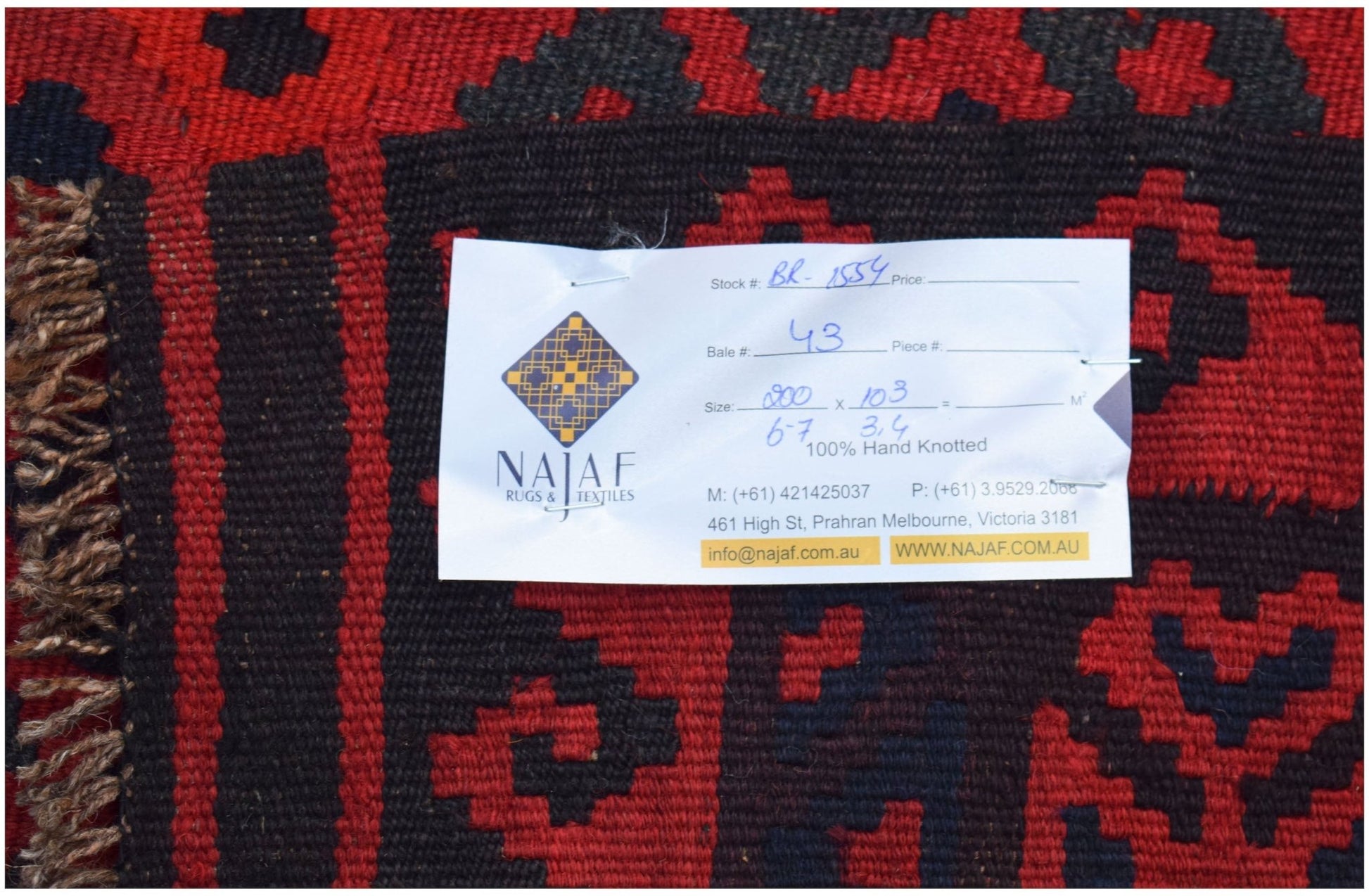 A handwoven Afghan Maimana kilim featuring a geometric pattern in red and black wool.
