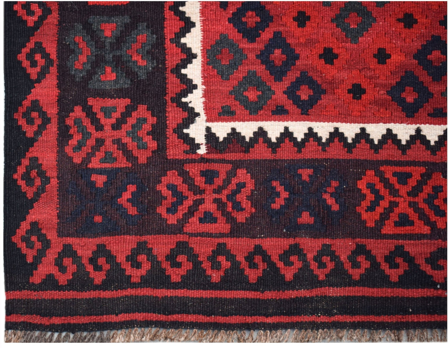 Handwoven Afghan Maimana kilim featuring a geometric pattern in red, black, and white wool.