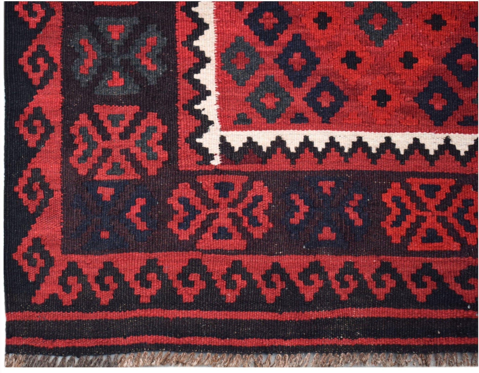 Handwoven Afghan Maimana kilim featuring a geometric pattern in red, black, and white wool.