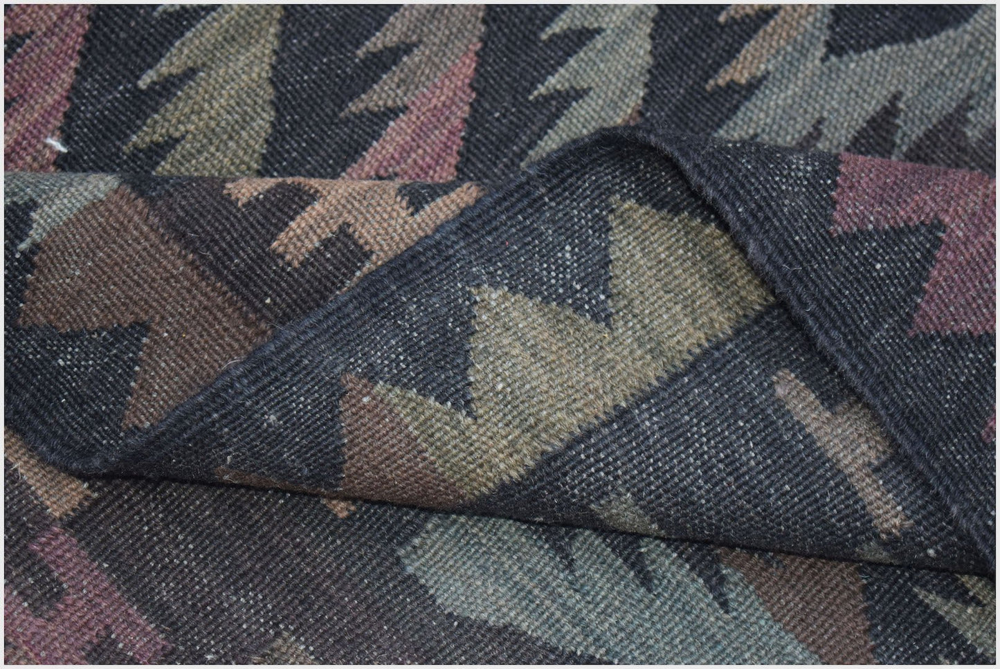 A handwoven Afghan Maimana kilim featuring a geometric pattern in muted earth tones.