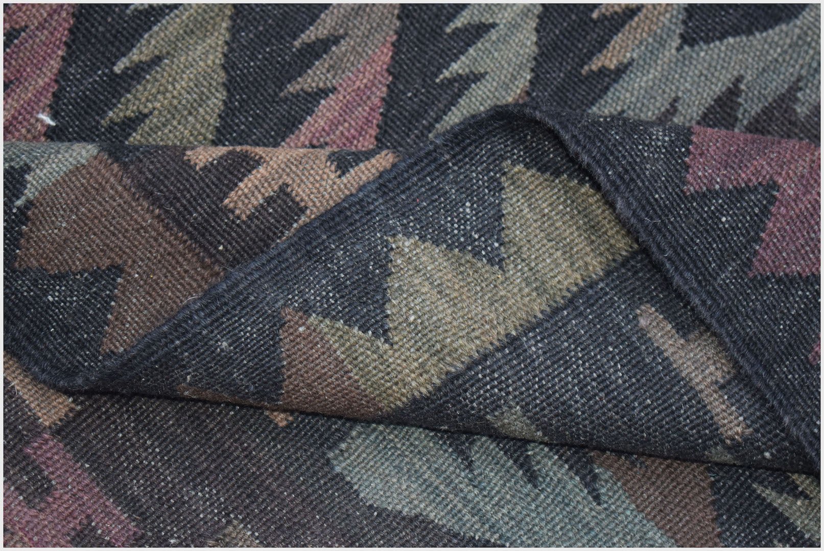 A handwoven Afghan Maimana kilim featuring a geometric pattern in muted earth tones.