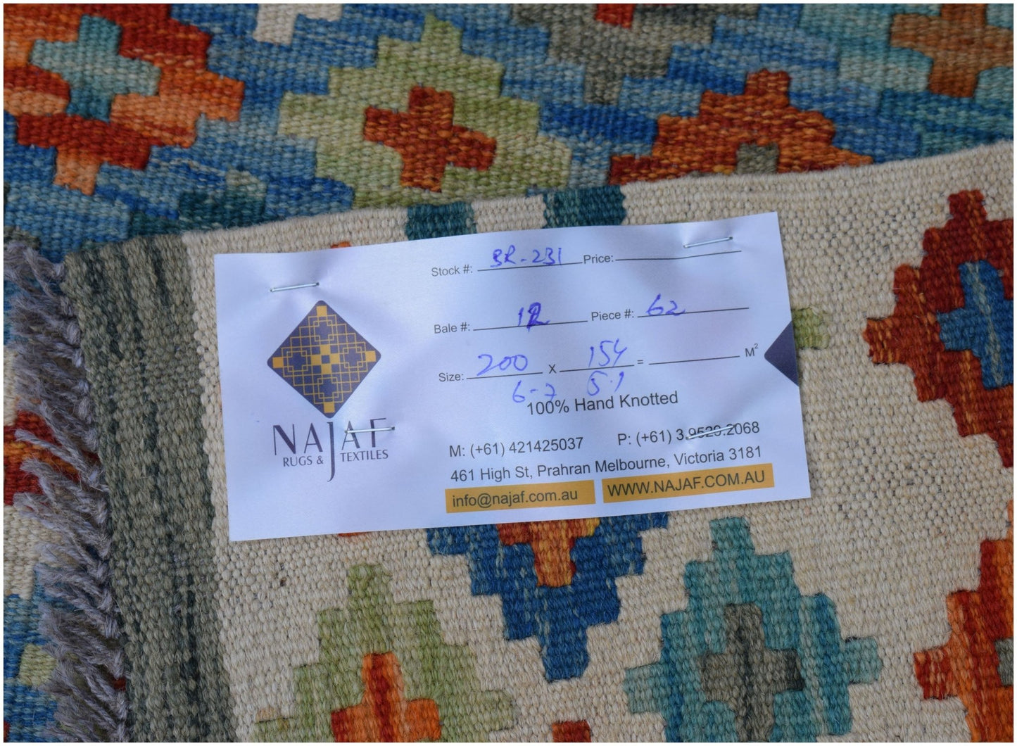 An Afghan Maimana Kilim rug featuring a geometric pattern in blue, orange, and cream tones.