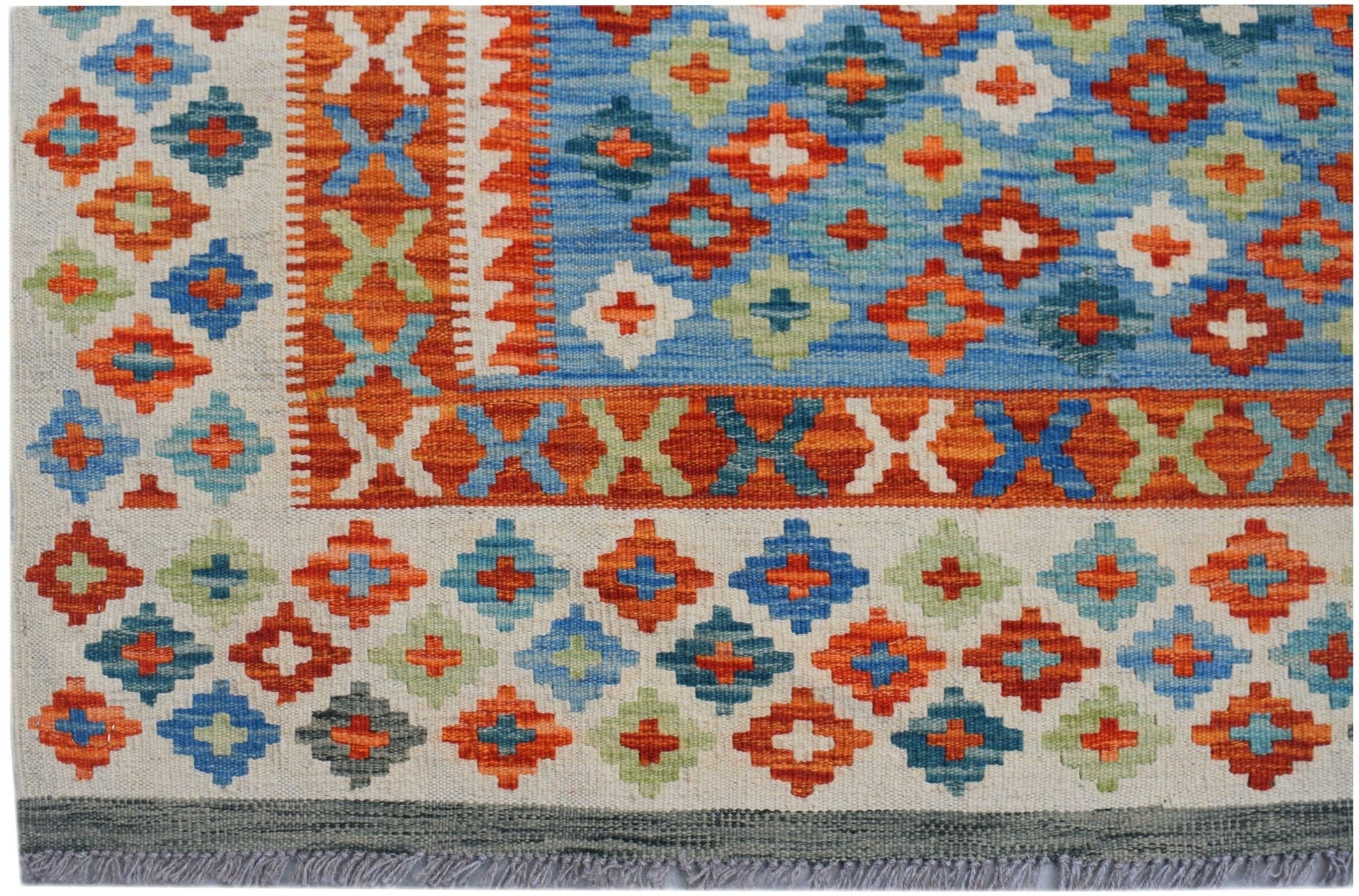 Handwoven Afghan Maimana kilim featuring a geometric pattern in blue, orange, and green wool.