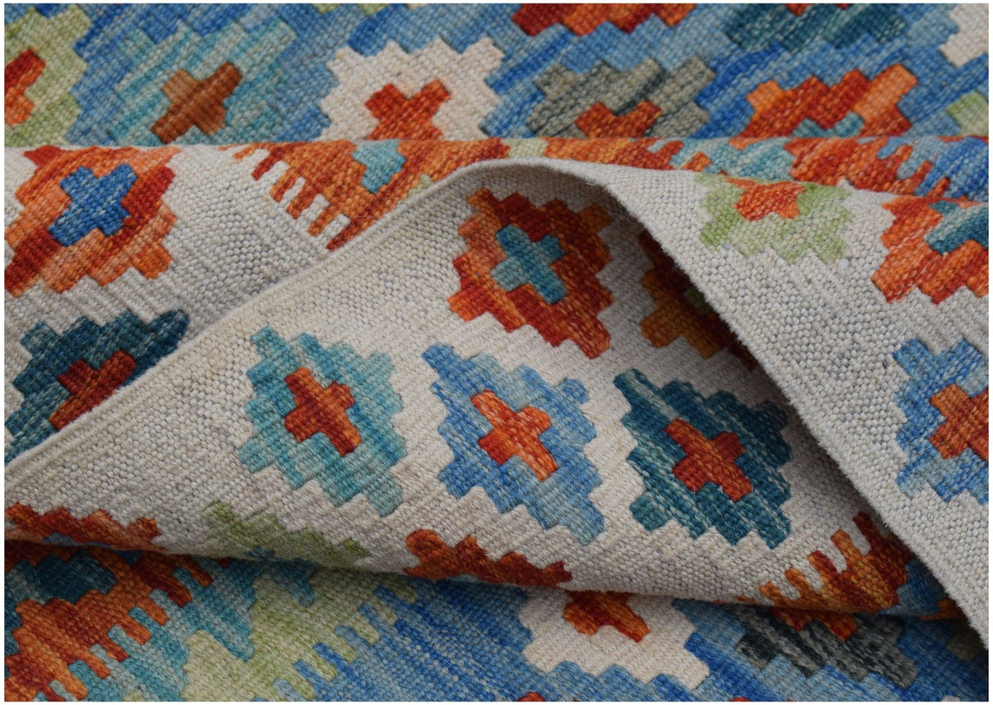 A handmade Afghan Maimana kilim rug featuring a geometric pattern in blue, orange, and cream.