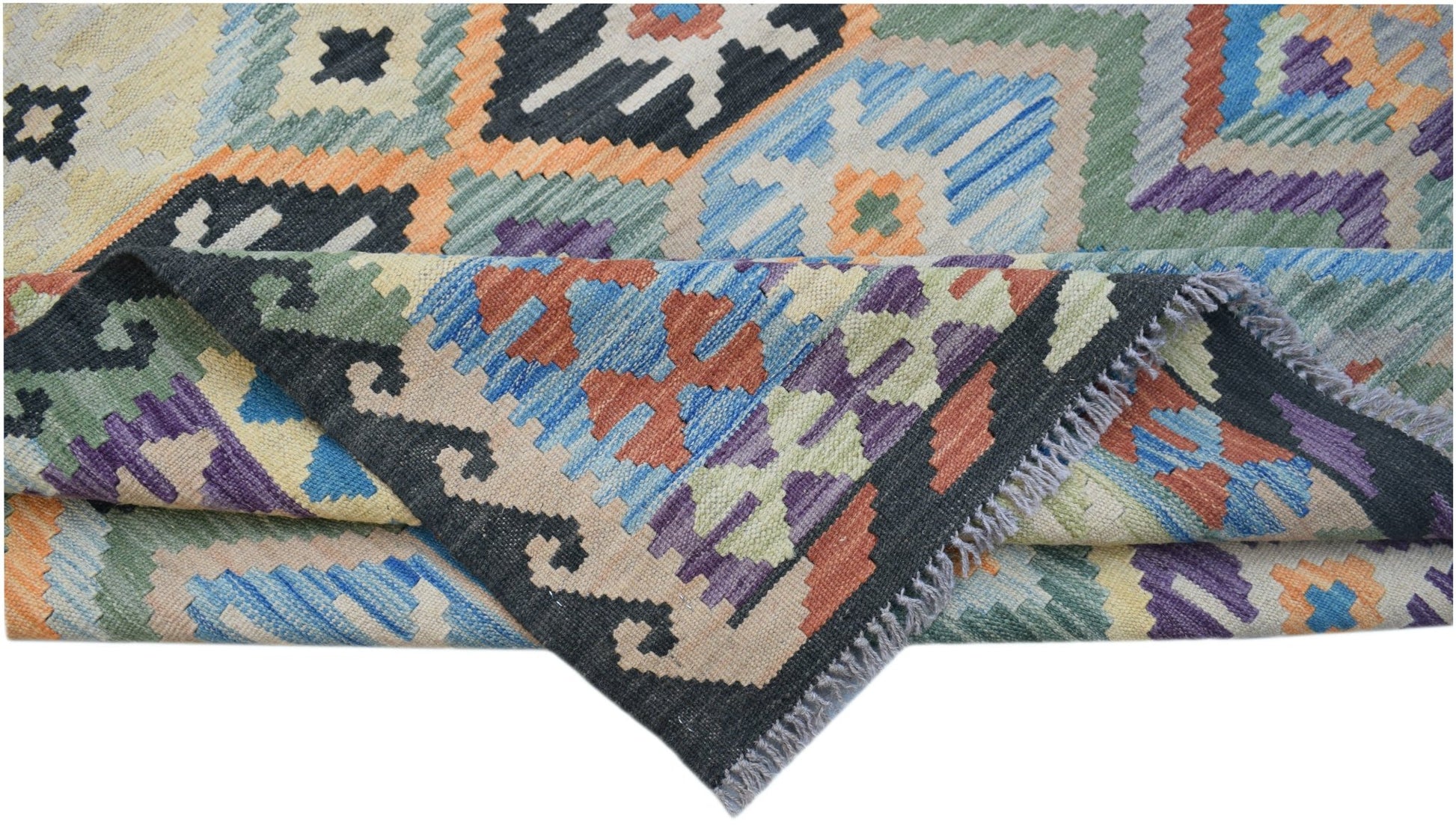 A handwoven Afghan Maimana kilim rug featuring a colorful geometric pattern and fringed edges.