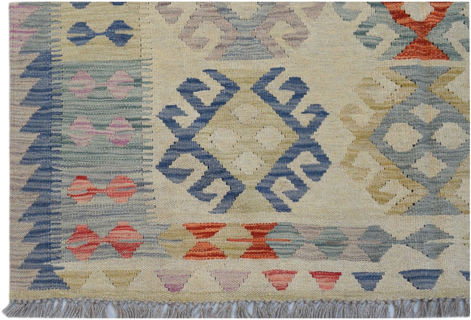 Handwoven Afghan Maimana kilim featuring geometric patterns in blue, red, and neutral tones.