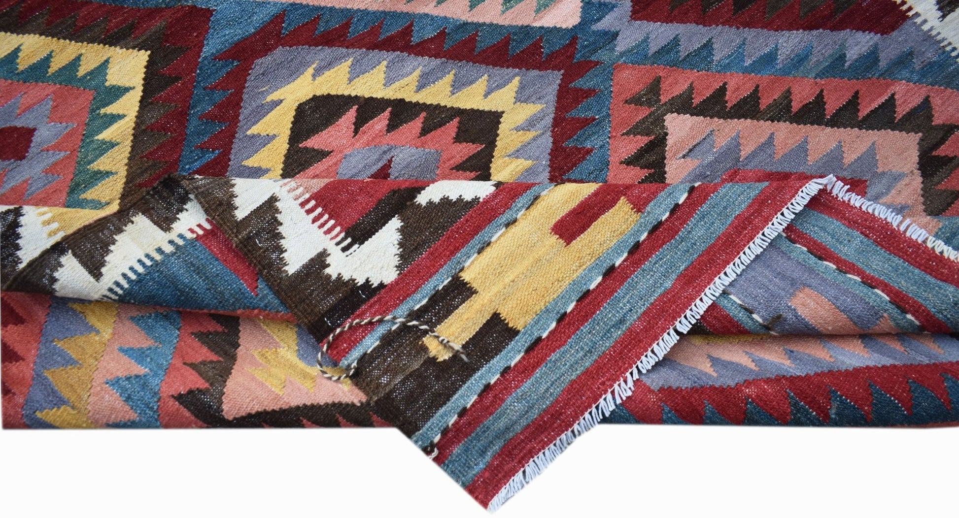 A handwoven Afghan Maimana kilim rug featuring a geometric pattern in vibrant, multi-colored wool.