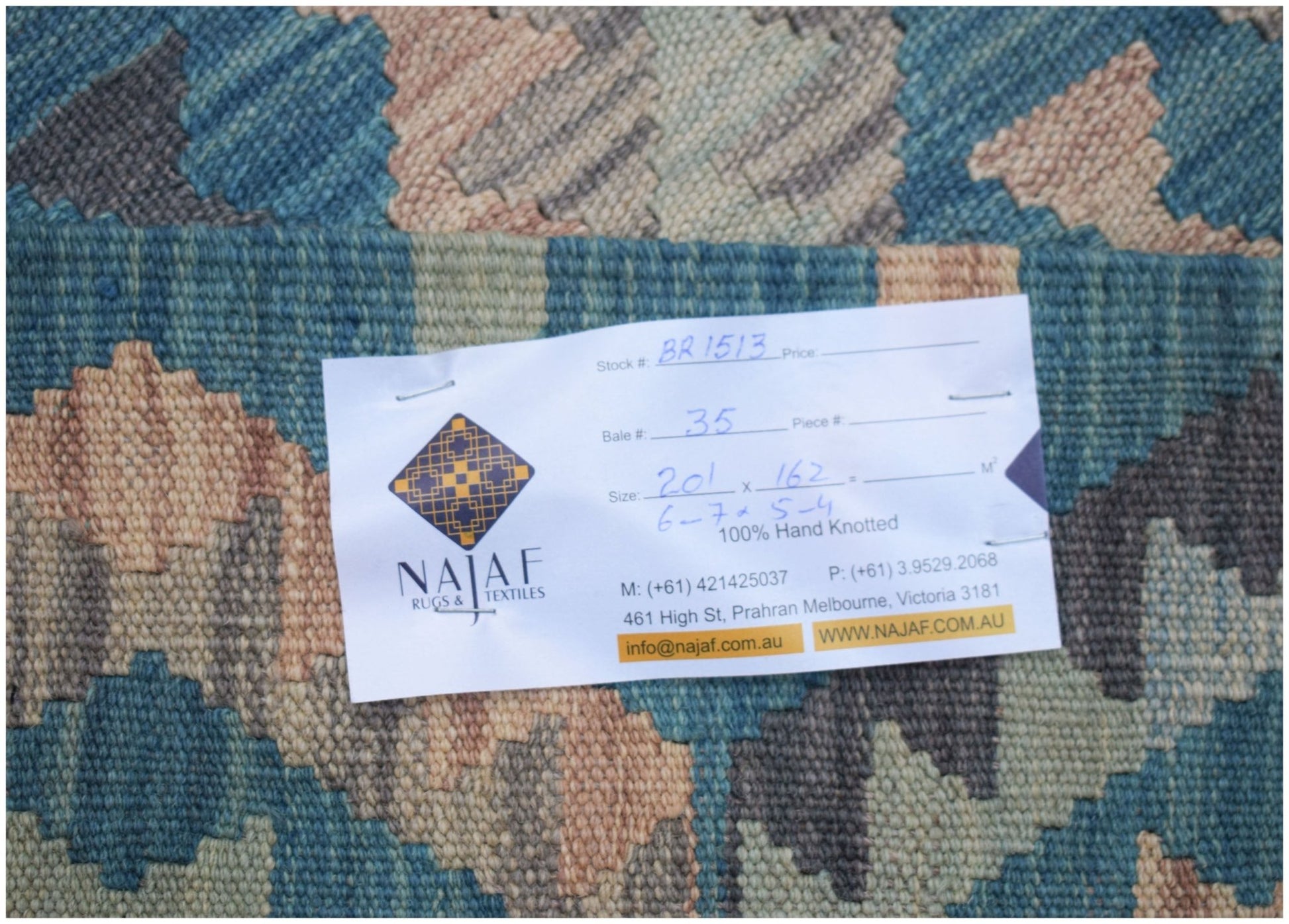 An Afghan Maimana Kilim rug featuring a geometric pattern in shades of blue, beige, and grey.