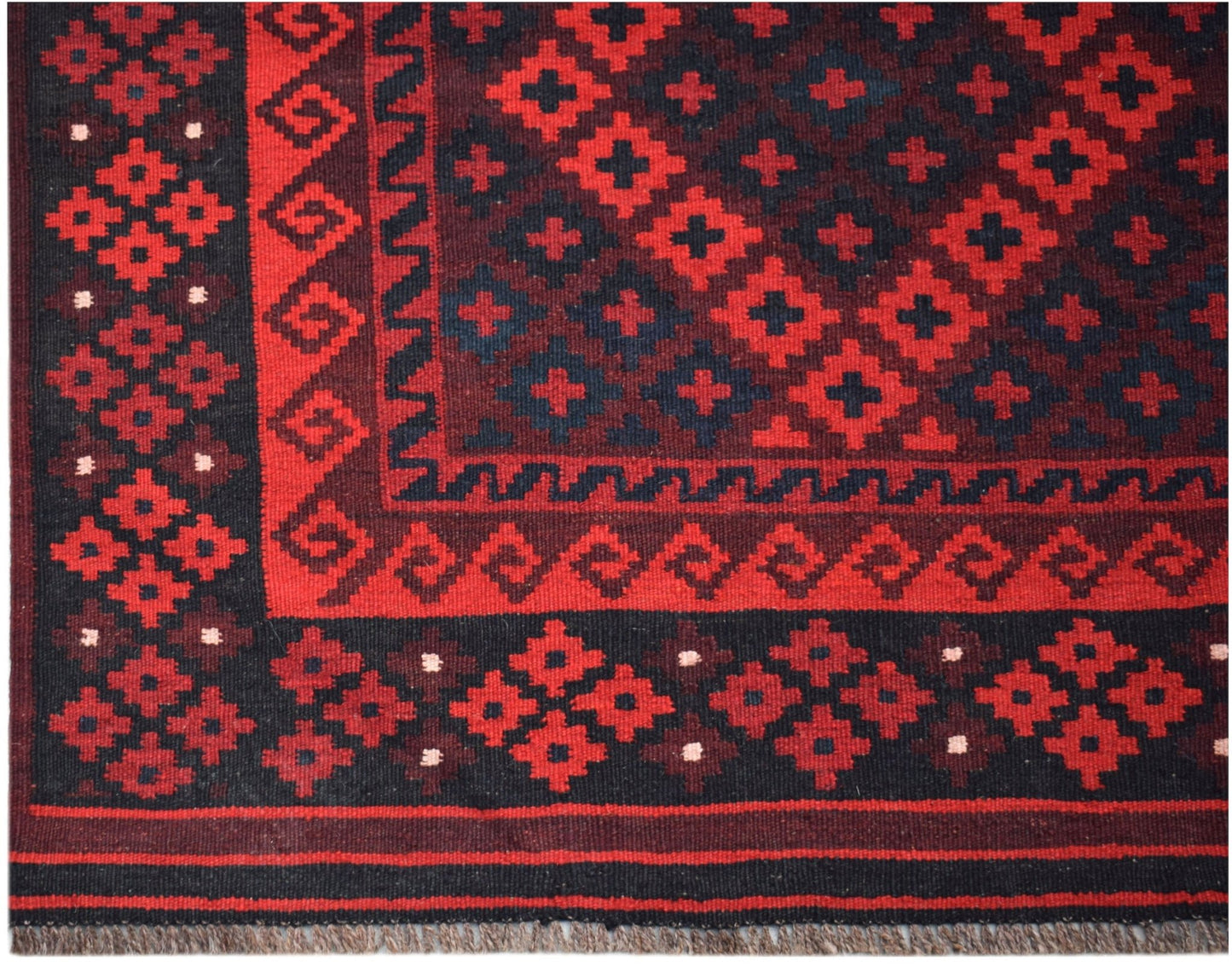 Handwoven Afghan Maimana Kilim rug featuring a geometric red and black pattern.