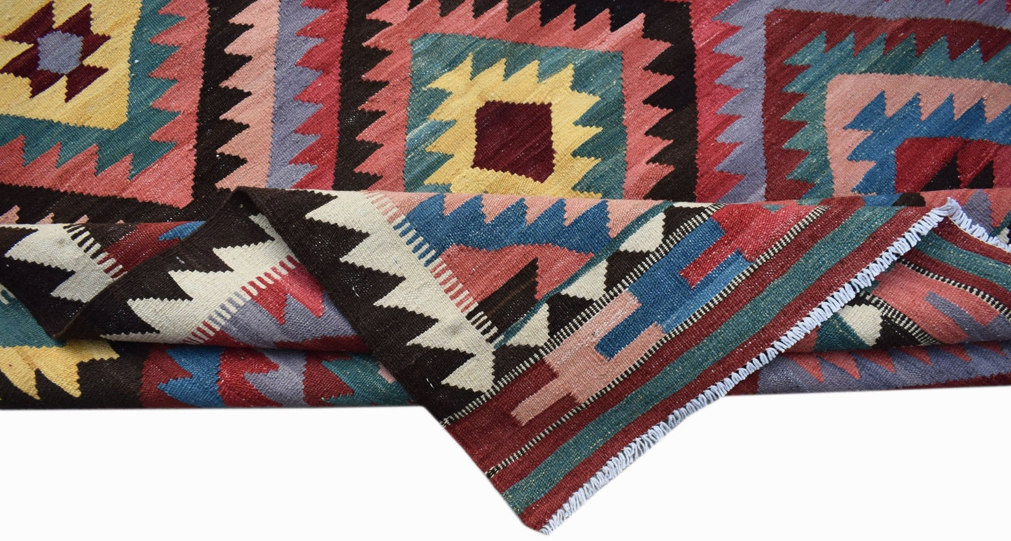 Handwoven Afghan Maimana kilim rug featuring a geometric pattern in vibrant multicolored wool.