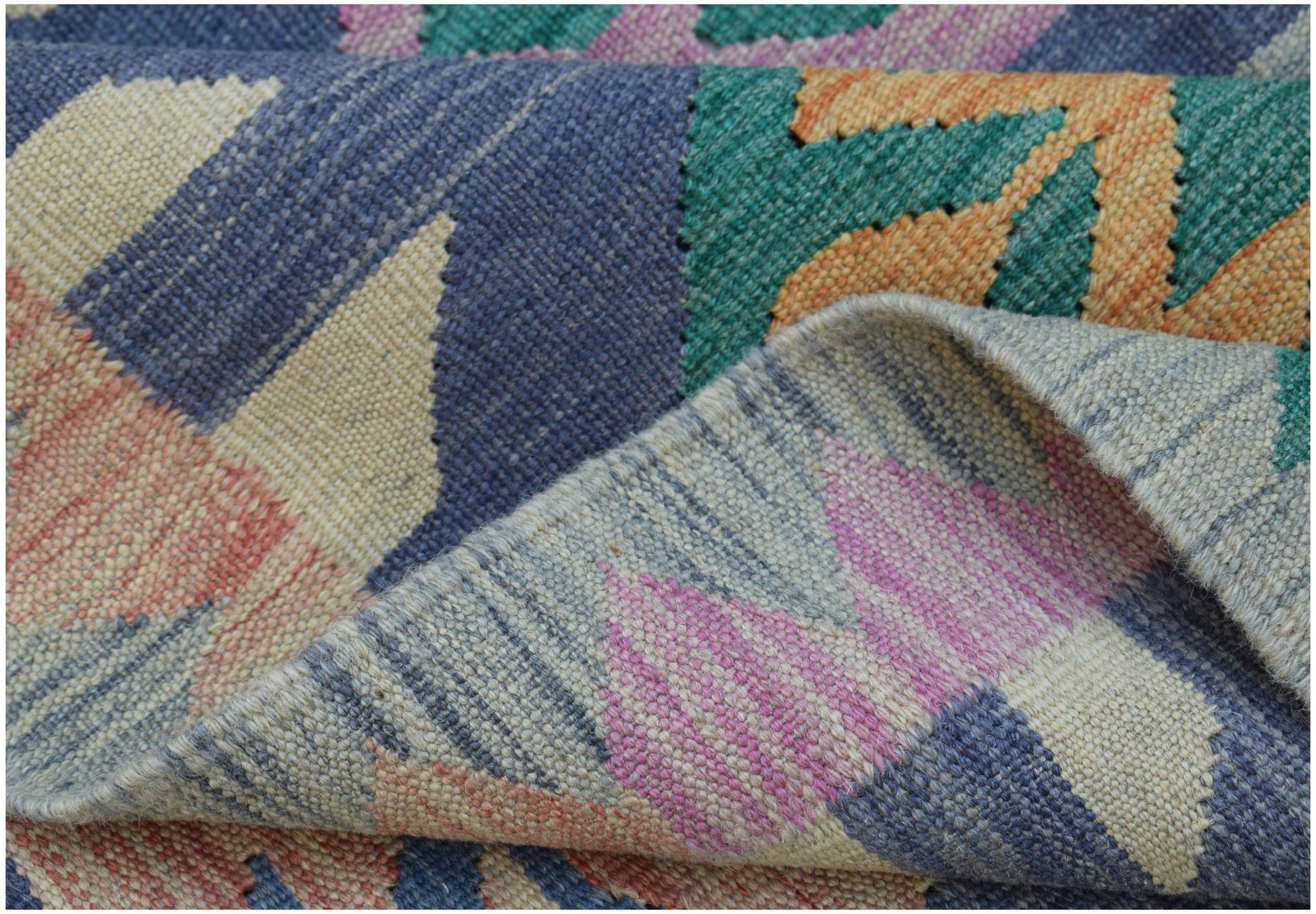 A close-up of a handwoven Afghan Maimana kilim featuring a colorful geometric pattern.