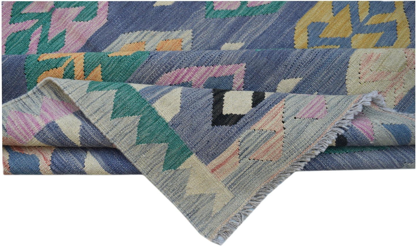A handmade Afghan Maimana kilim featuring a geometric pattern in blue, pink, green, and yellow.