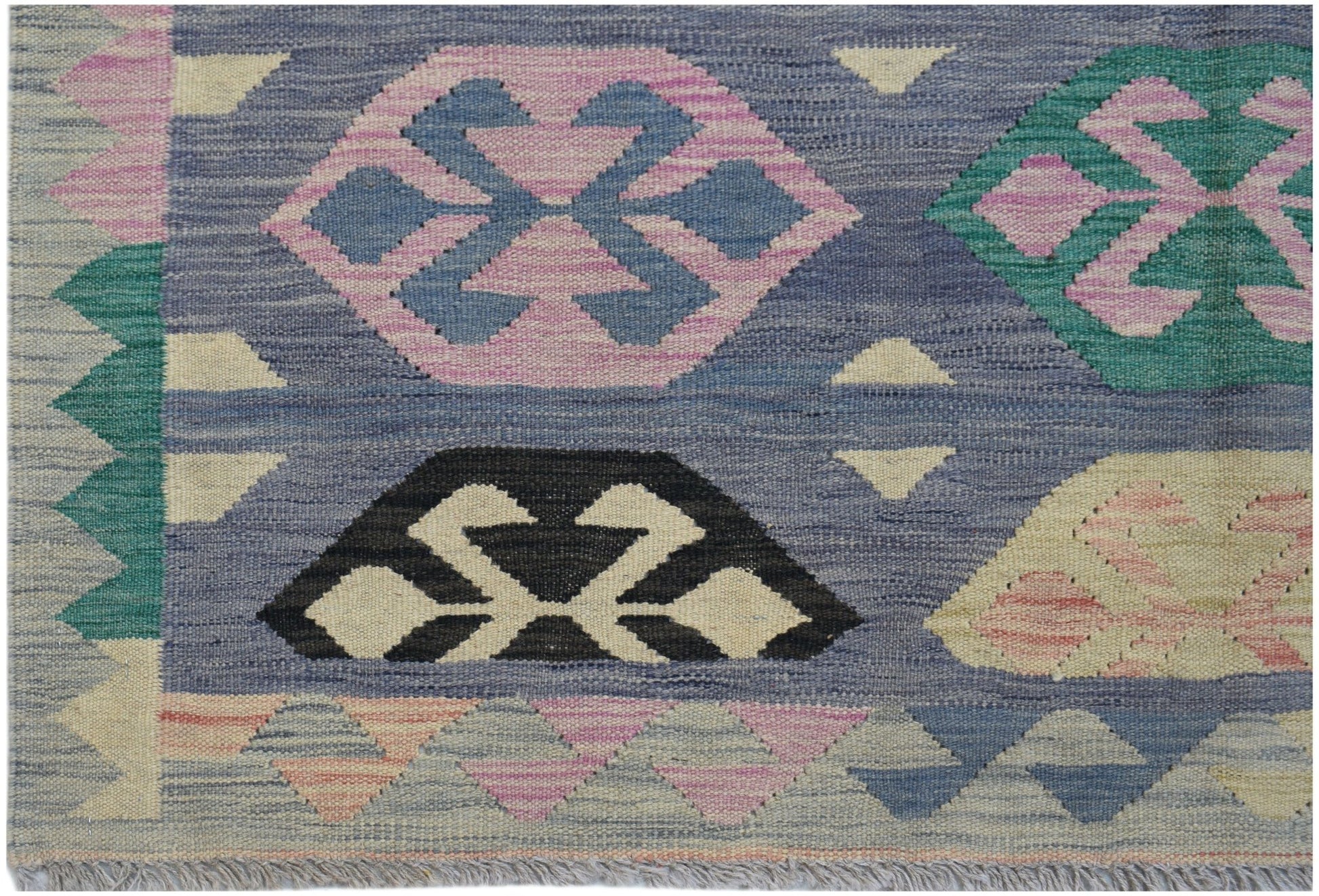 Handwoven Afghan Maimana kilim rug featuring a geometric pattern in blue, pink, and green wool.