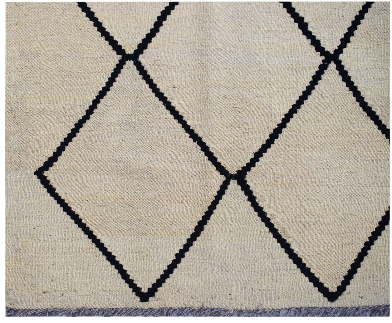 Handwoven Afghan Maimana kilim rug featuring a black geometric diamond pattern on a cream background.