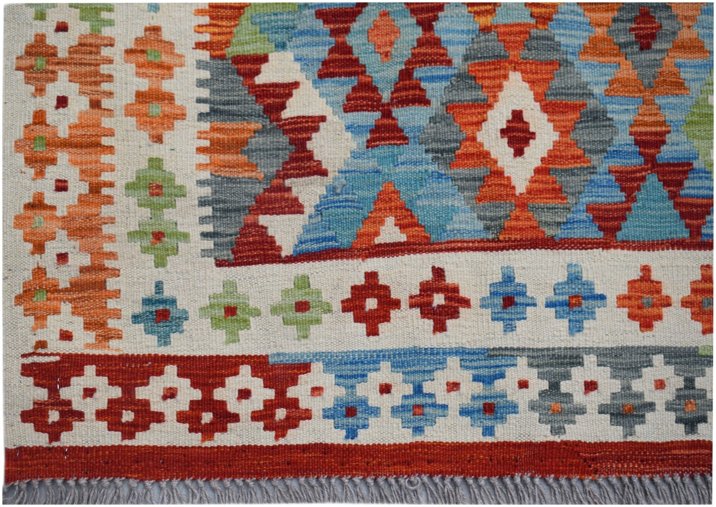 Handwoven Afghan Maimana kilim featuring a vibrant geometric pattern in wool.
