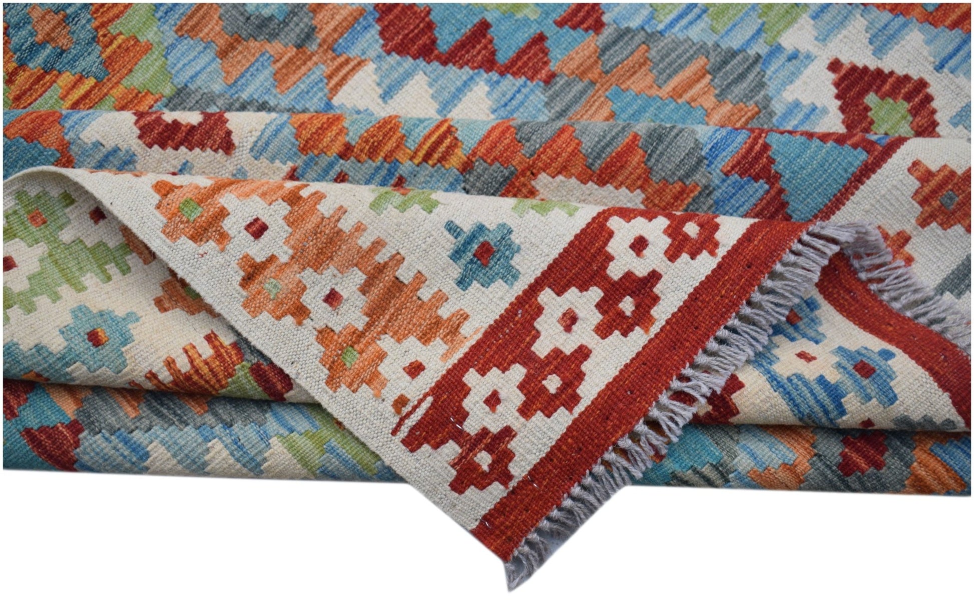 A handmade Afghan Maimana kilim rug featuring a geometric pattern in red, blue, and orange wool.