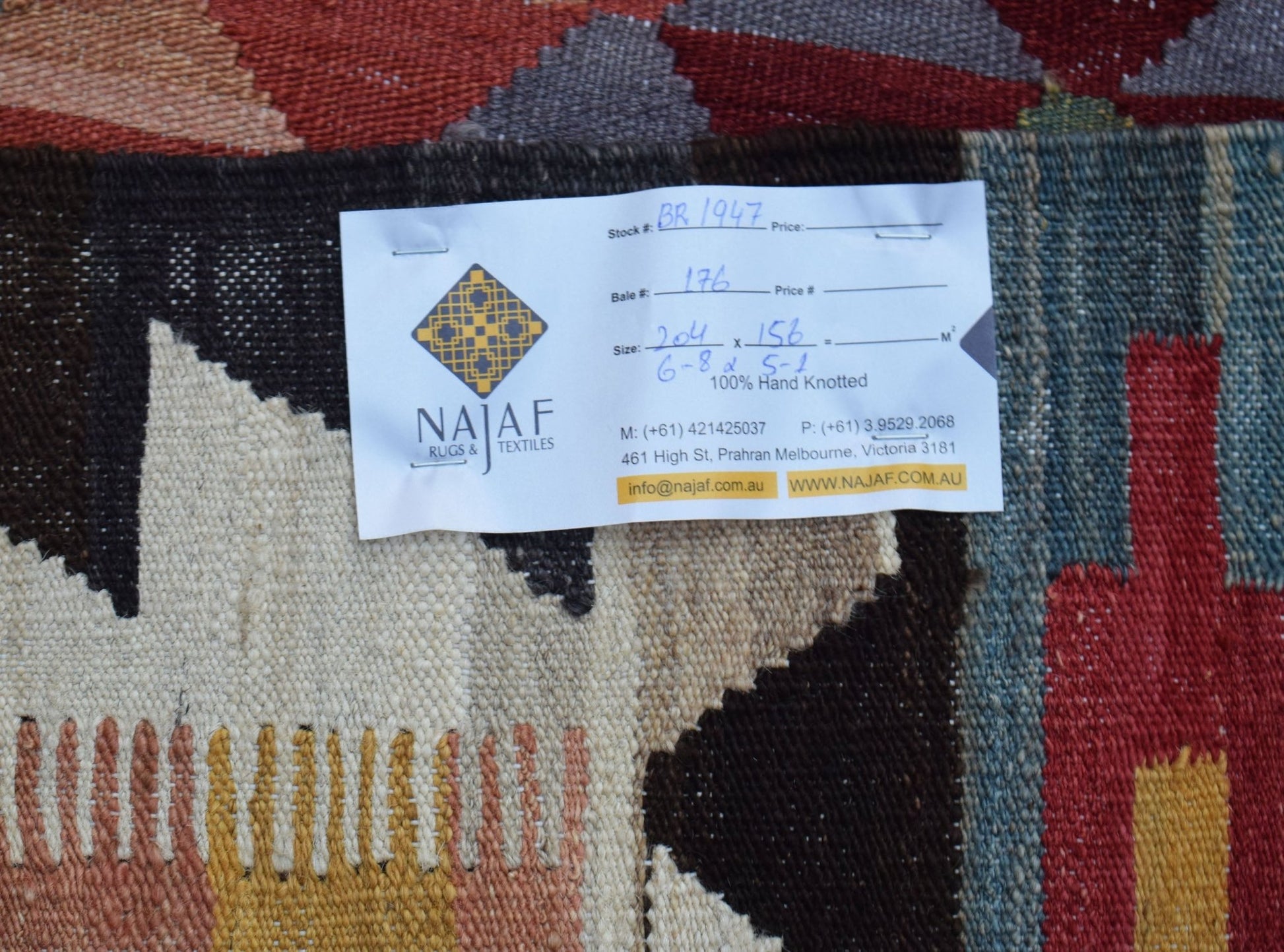 A handmade Afghan Maimana kilim featuring a geometric pattern in rich, earthy tones.