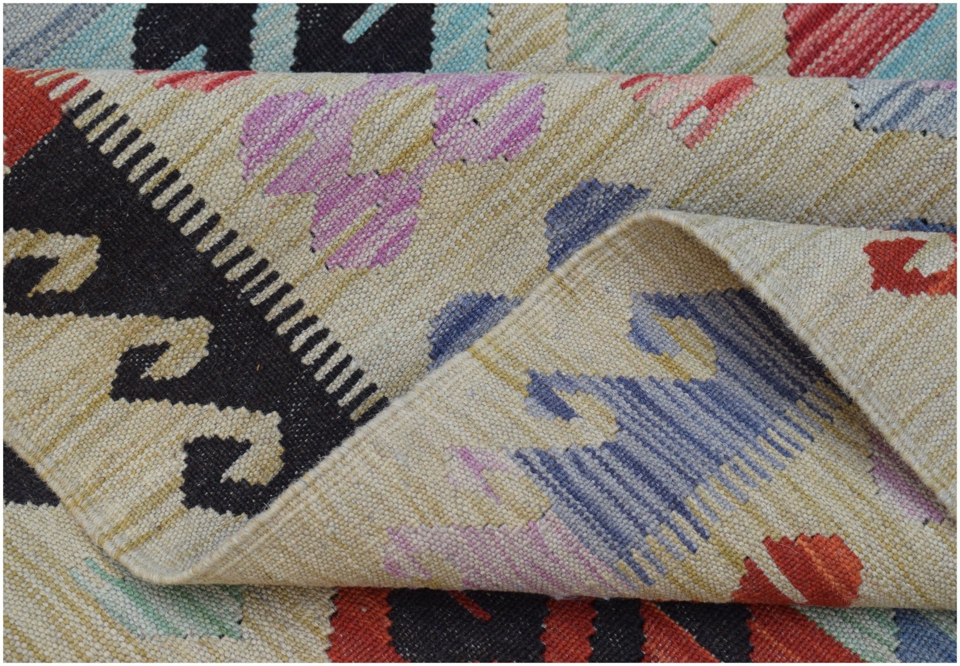 A handwoven Afghan Maimana kilim featuring a geometric pattern in red, blue, and purple wool.