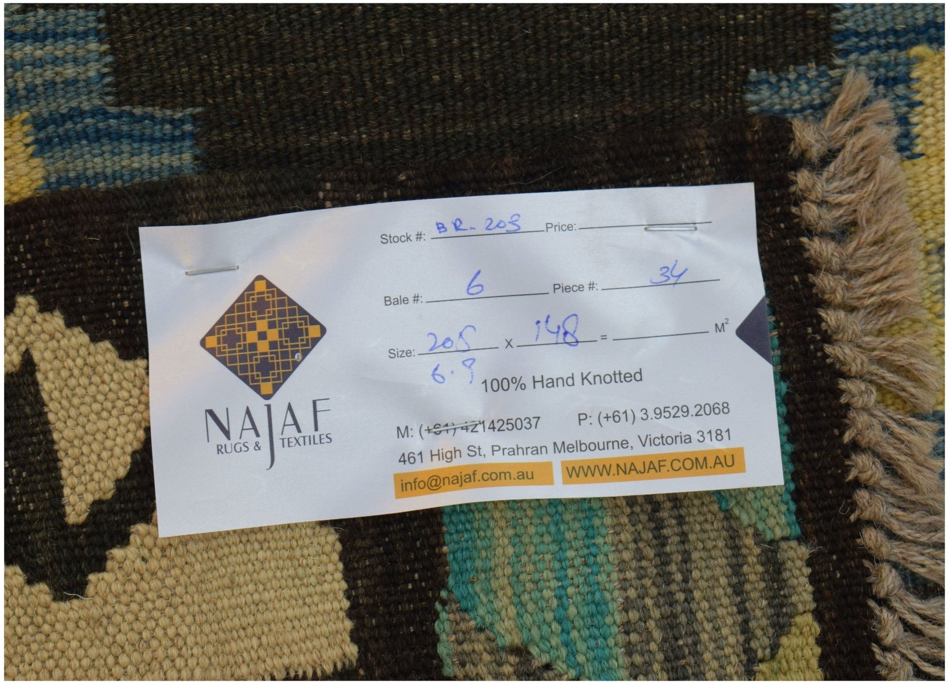 An Afghan Maimana kilim rug featuring a geometric pattern in shades of brown, blue, and cream.