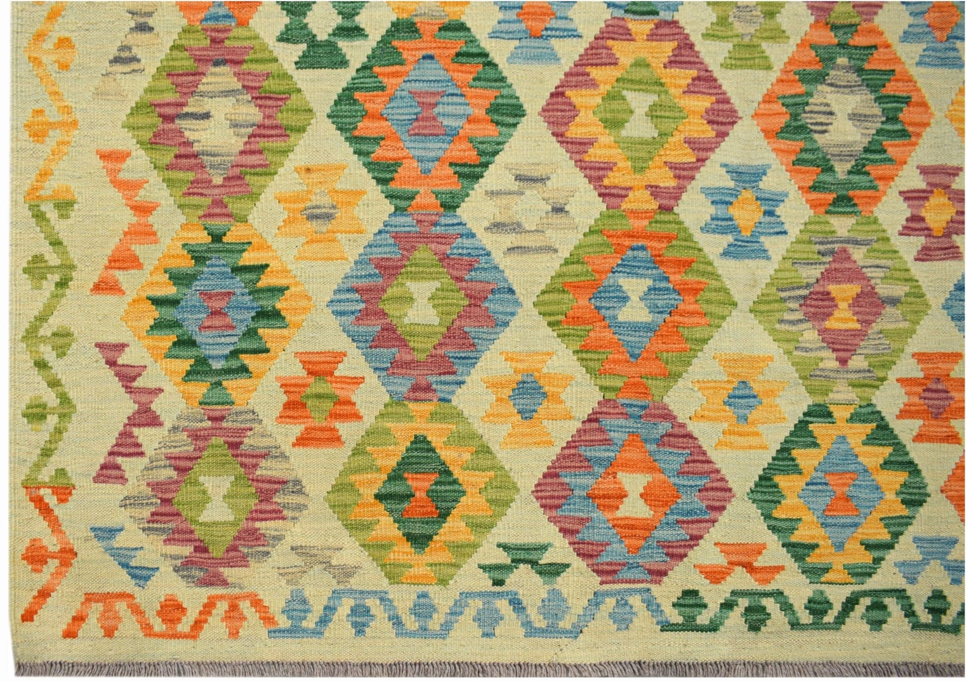 Handwoven Afghan Maimana kilim rug featuring a colorful geometric diamond pattern on a cream base.