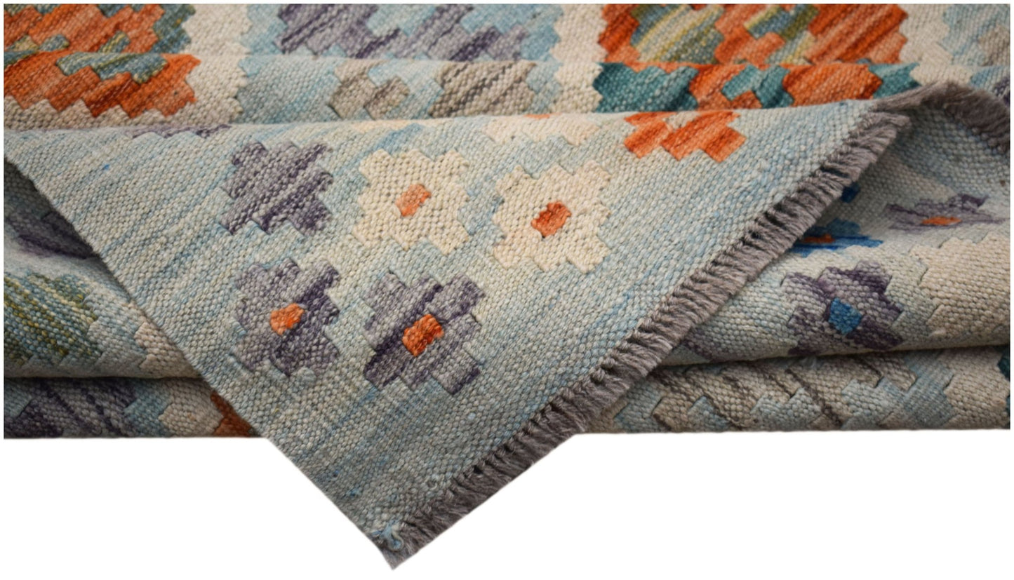 A handwoven Afghan Maimana kilim rug featuring a geometric pattern in blue, orange, and cream.
