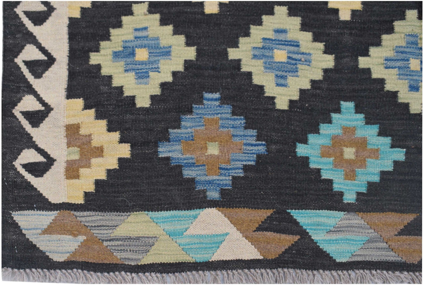 Handwoven Afghan Maimana kilim featuring a black background with colorful geometric diamond motifs.