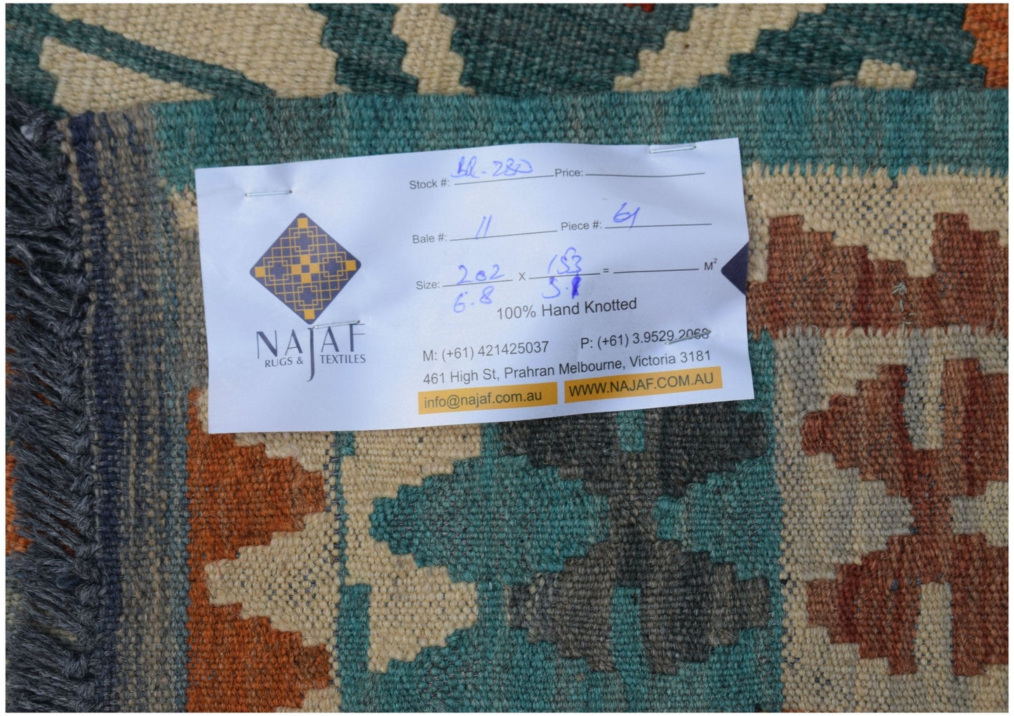 A handwoven Afghan Maimana kilim featuring a geometric pattern in teal, orange, and cream wool.